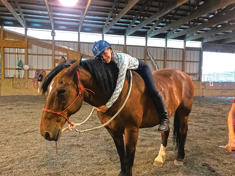 Horse being hugged by his young rider