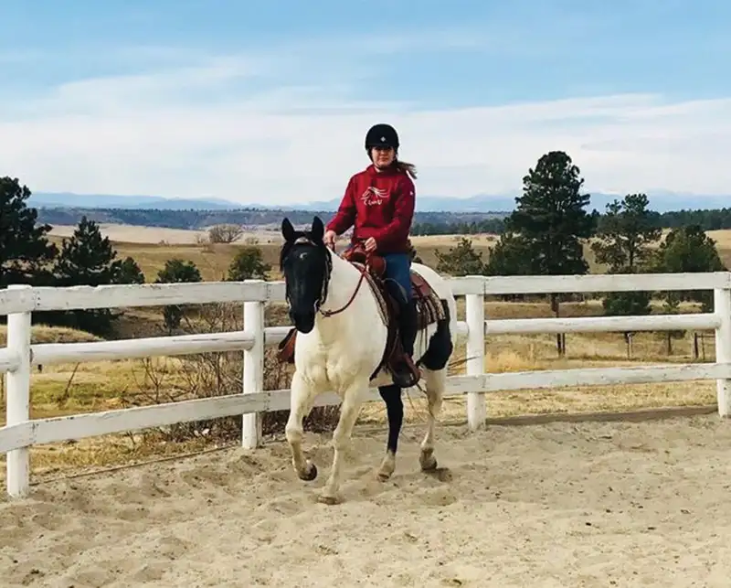 woman riding a horse in an arena