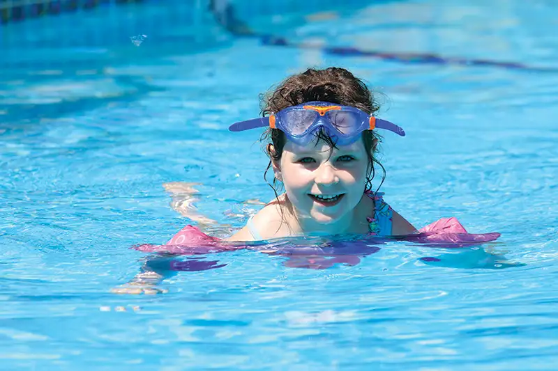 little girl smiling in the pool