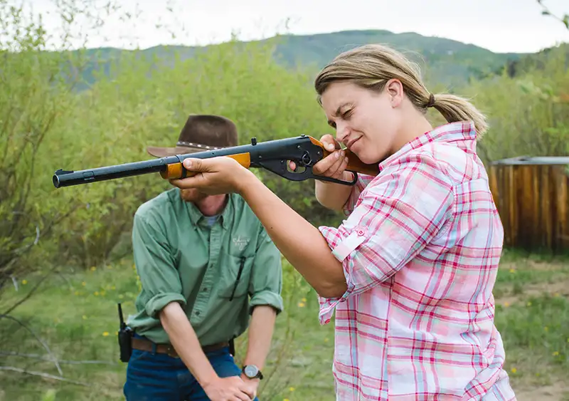 woman aims with a beebee gun