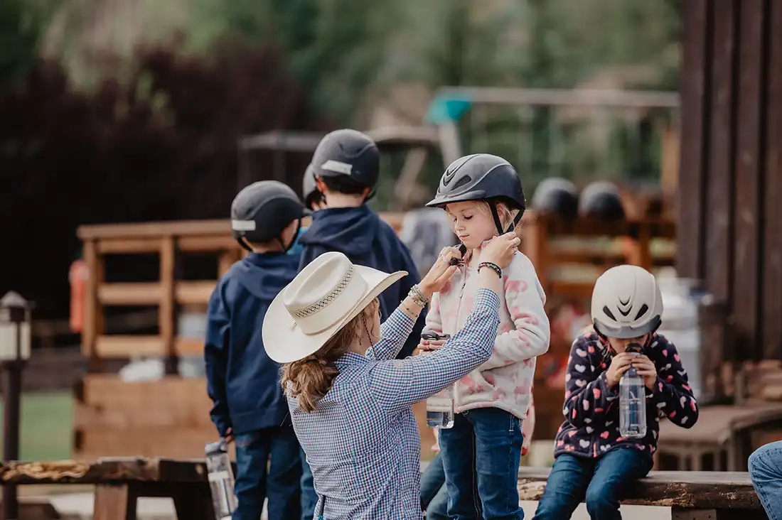 a counselor adjusts the helmet on a child