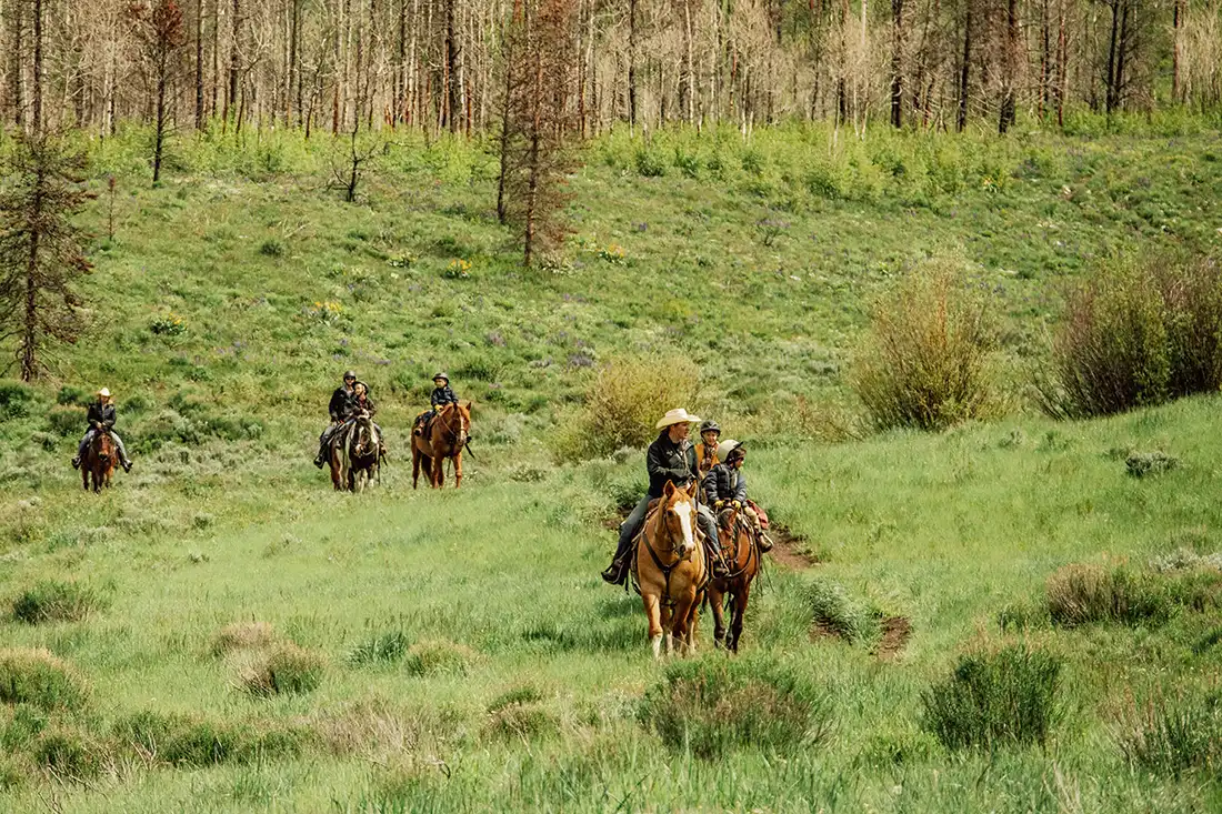 Kids out on a trail ride with C Lazy U wranglers